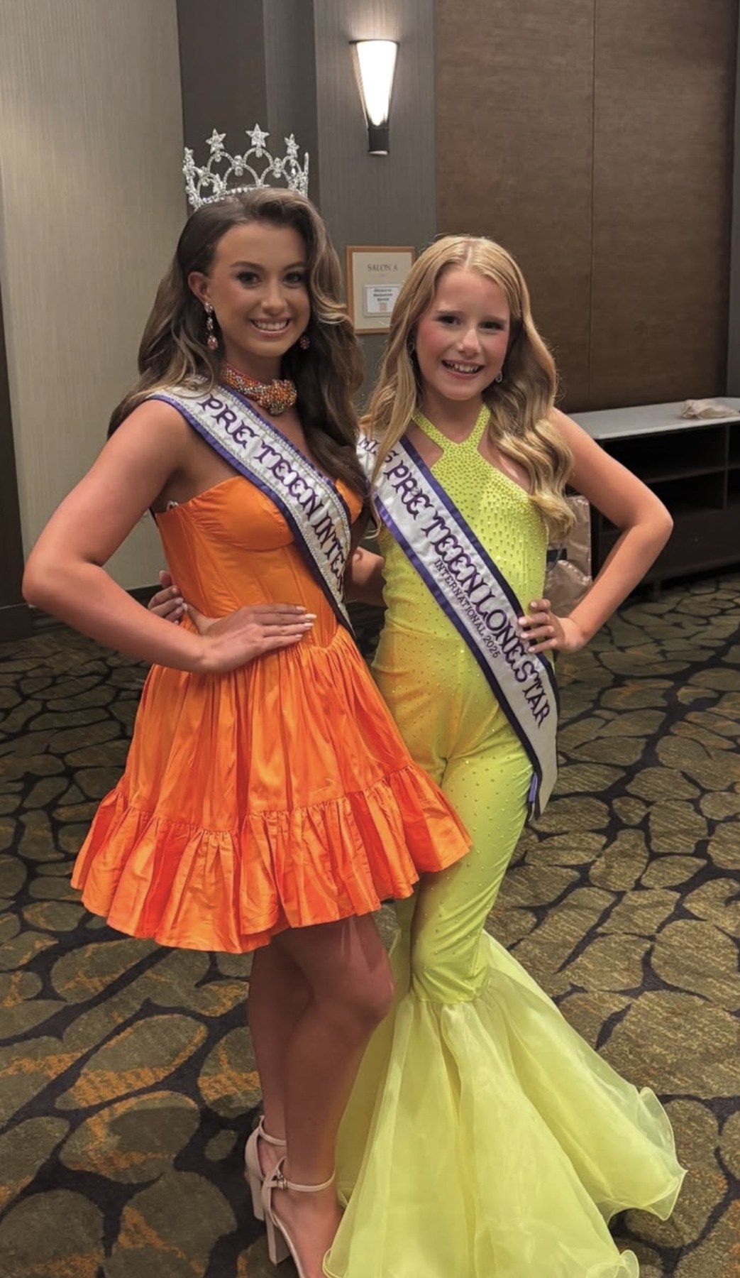 Two Pre Teen titleholders posing together in orange and lime outfits